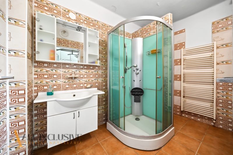 Bathroom in a family house with a shower and ceramic tiles.