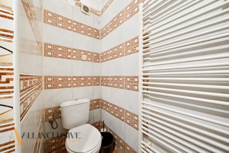 A bathroom with tiles in a family house, white heating, patterned tiles.