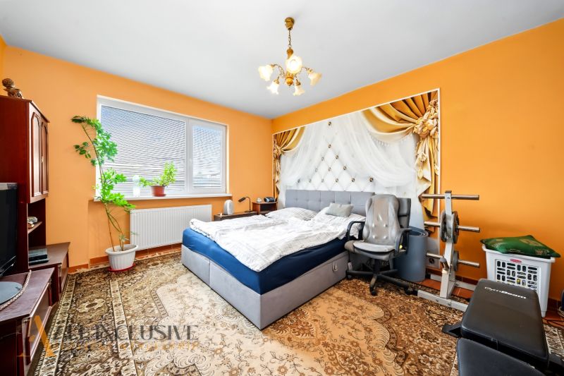 Bedroom with a bed and exercise equipment in a family house.