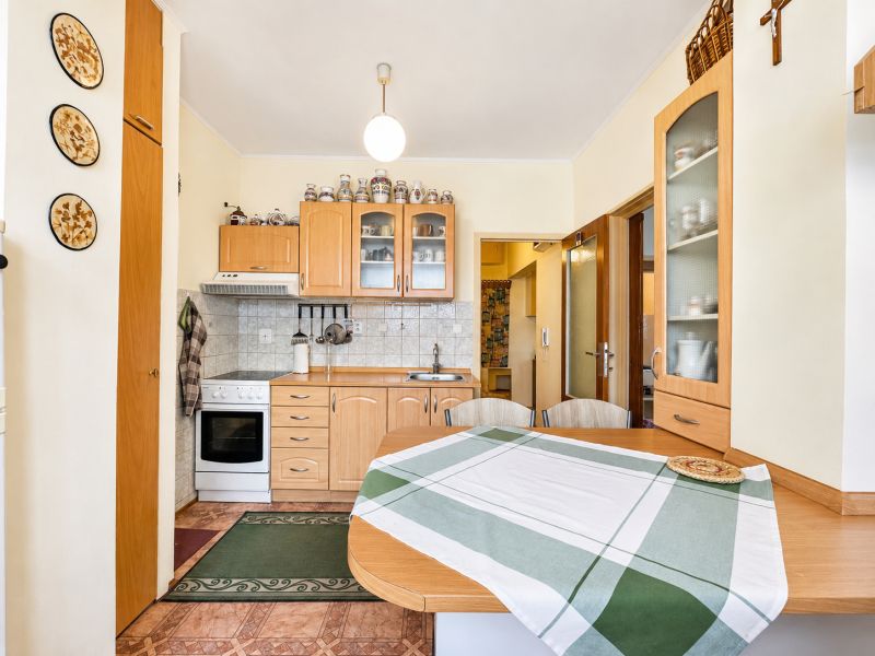 A kitchen unit in a one-room apartment with wooden accessories and appliances.