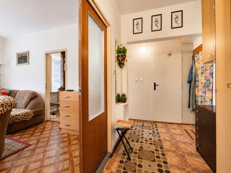 Interior of a 1-room apartment with a wooden decor floor and furniture.