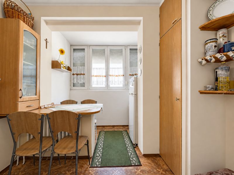 Dining area with wooden chairs and table, floor with wooden decor.