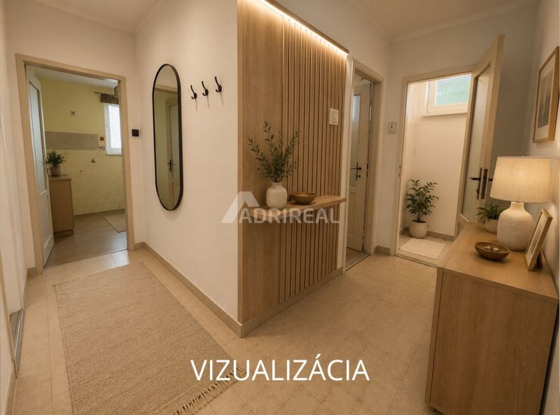 Interior of a 2-room apartment with tiles, flowers, and a large mirror on the wall.