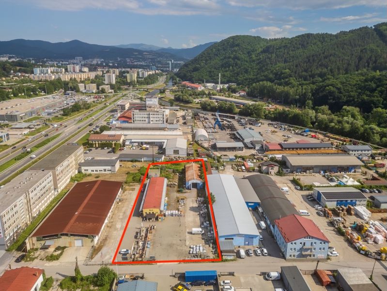 A building in the industrial zone on Zvolenská Street in Banská Bystrica surrounded by nature and buildings.