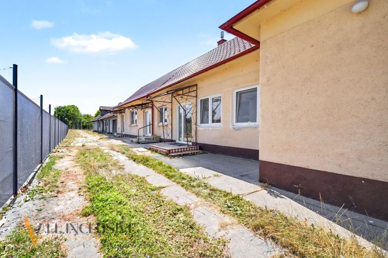 A family house in Vydrany with a veranda and a grassy plot, surrounded by a fence.