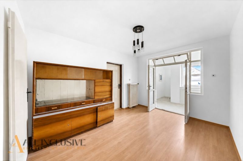 A room in a family house with a wooden decor floor and older furniture.