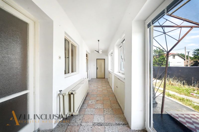 A bright hallway with windows and tiles in a family house.