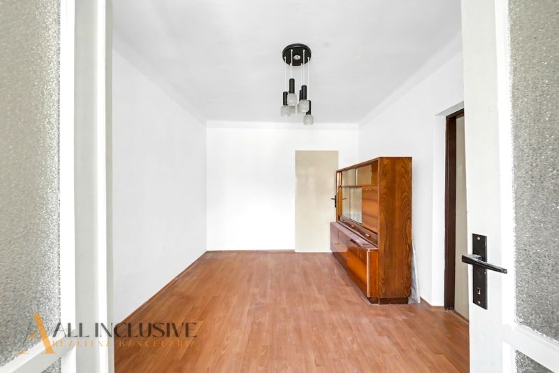 A room with a wooden decor floor and a wooden wardrobe in a family house.