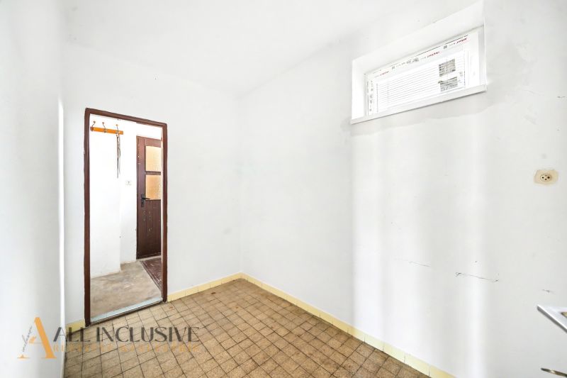 A room in a family house with a tiled floor and white walls.