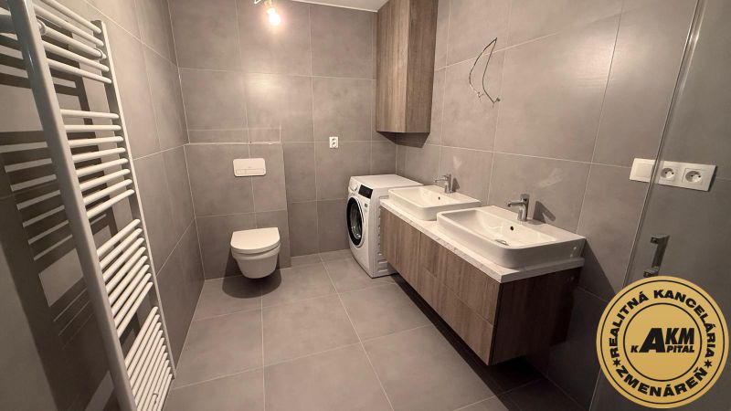 A bathroom with a double sink, a washing machine, and a toilet in a 3-room apartment.