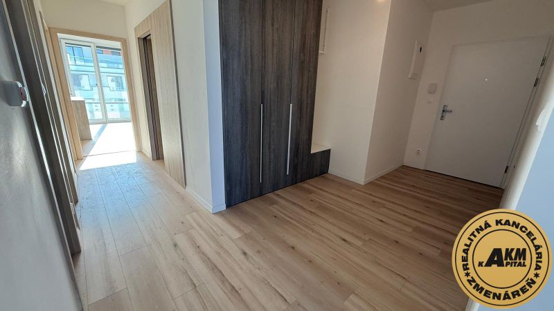 A hallway in a 3-room apartment with a wooden decor floor and a built-in wardrobe.
