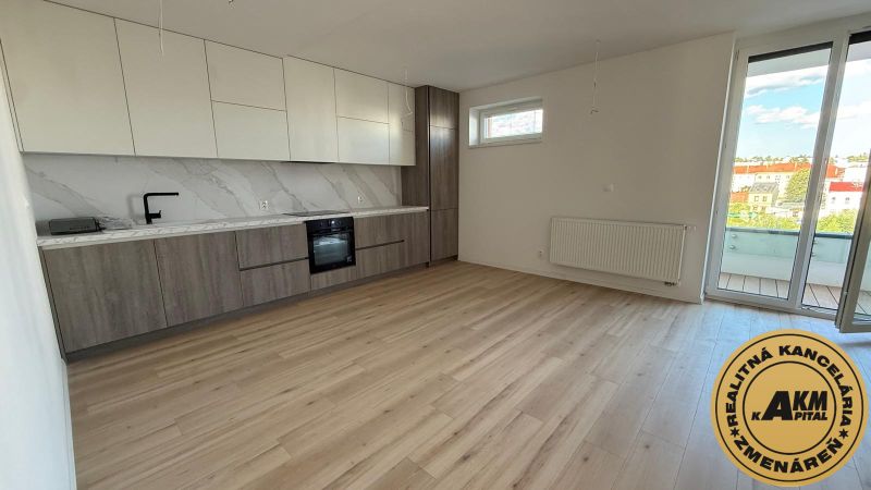 A kitchen in a 3-room apartment with a wooden decor floor and a balcony.