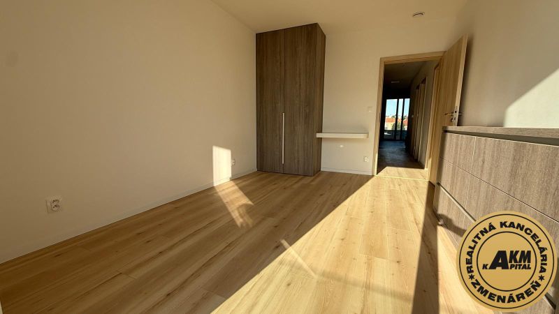 A room in a 3-room apartment with a wooden decor floor and a built-in wardrobe.