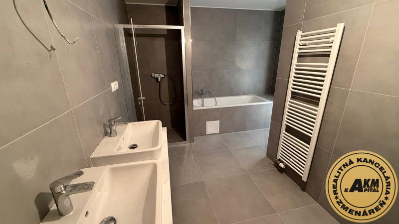 A bathroom with two sinks, a bathtub, and a shower in a 3-room apartment.