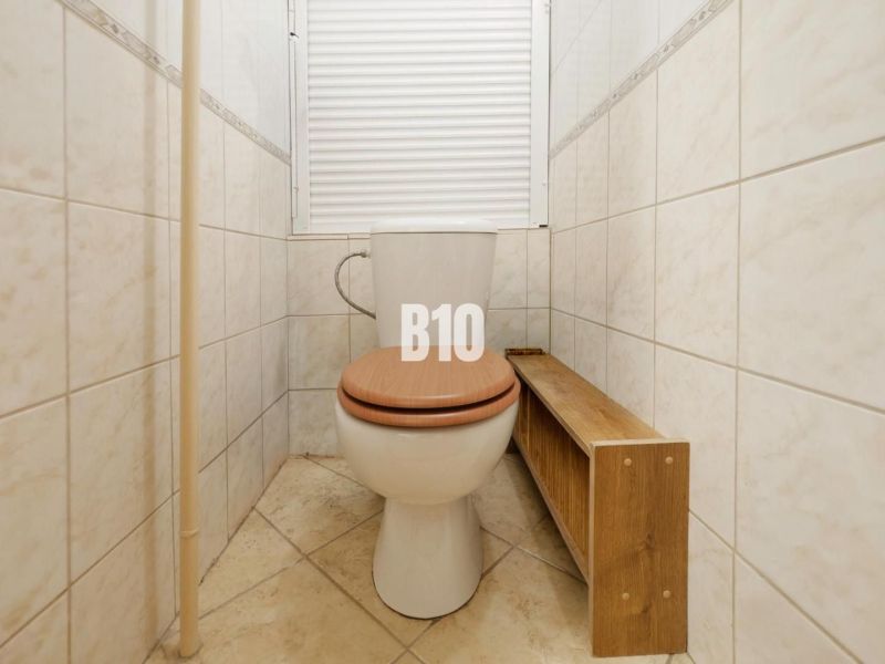 Bathroom with toilet and wooden decor flooring in a 2-room apartment.