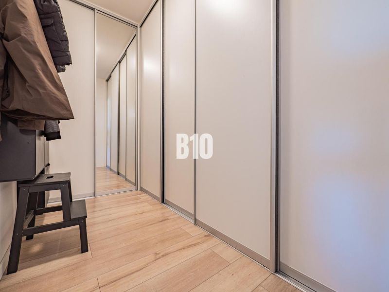 A hallway in a 3-room apartment with storage space and a floor with a wood decor.