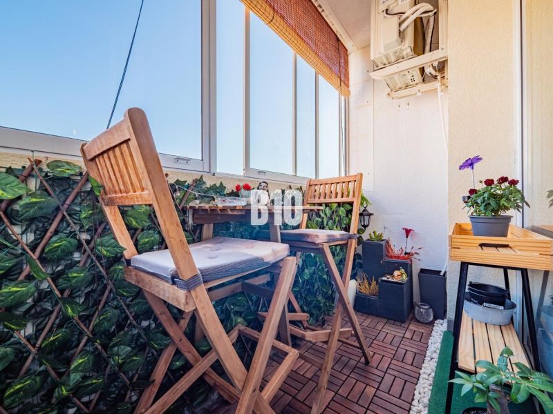 Glazed balcony terrace with wood-decor flooring and plants in a 3-room apartment.