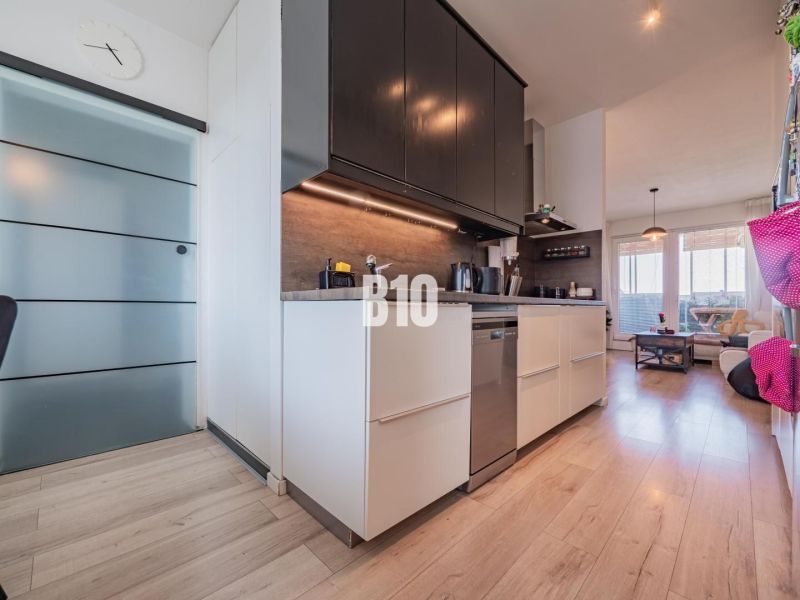 Kitchen and living room in a 3-room apartment with a wooden decor floor.