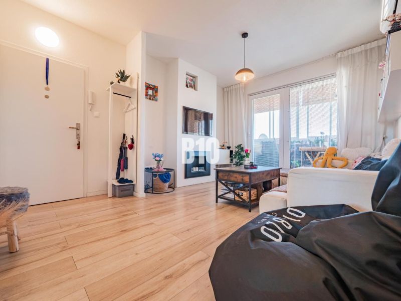 Living room in a 3-room apartment with a wooden decor floor and comfortable seating.