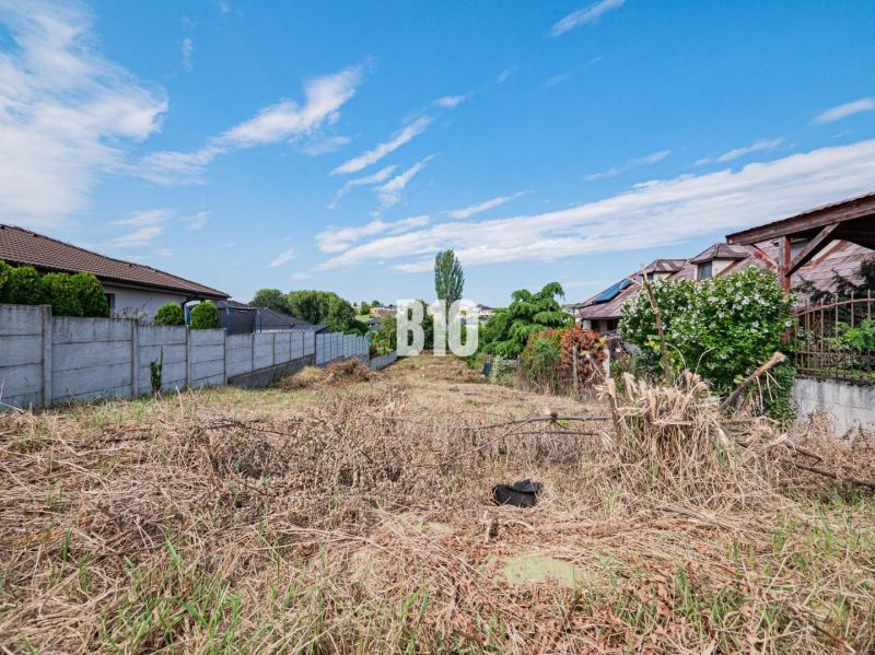 Plots - housing in Nitra, bordered by a fence, with a view of the blue sky.