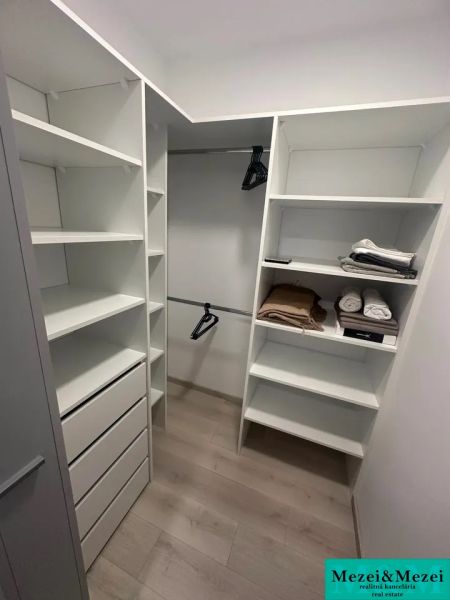 Storage space with shelves, drawers, and a wooden decor floor in a 2-room apartment.