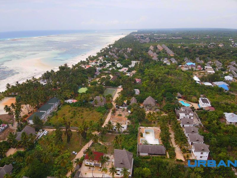 A view of the coastline and family homes in Fumba Town, surrounded by tropical nature.