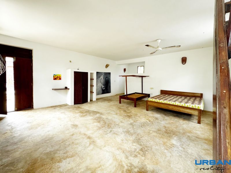 Bedroom in a family house with built-in wardrobes and wall decorations.