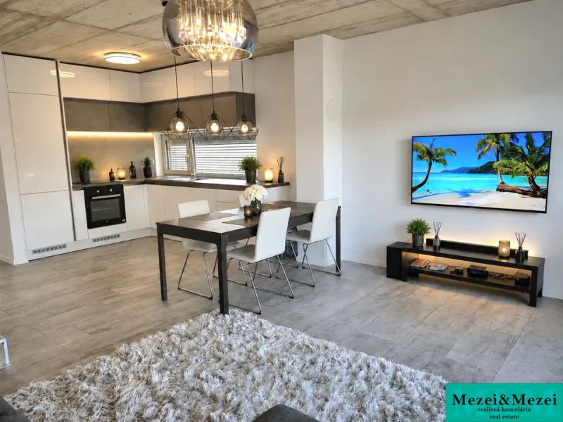 Living room with kitchen, dining table, and wooden decor flooring in a family house.