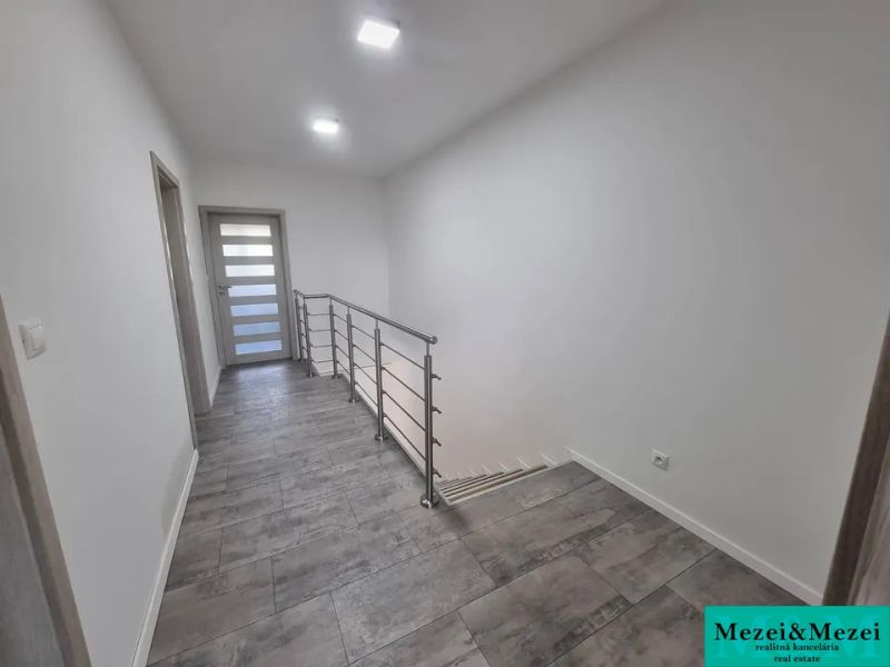 A hallway in a family house with a staircase and ceramic tiles.