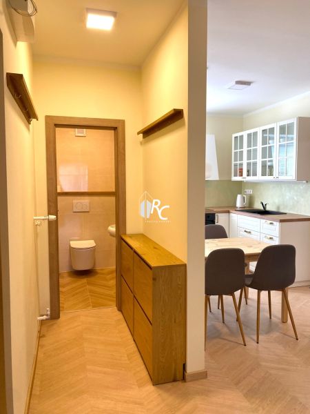 Interior of a 3-room apartment with a kitchen, dining area, and flooring with a wood decor.