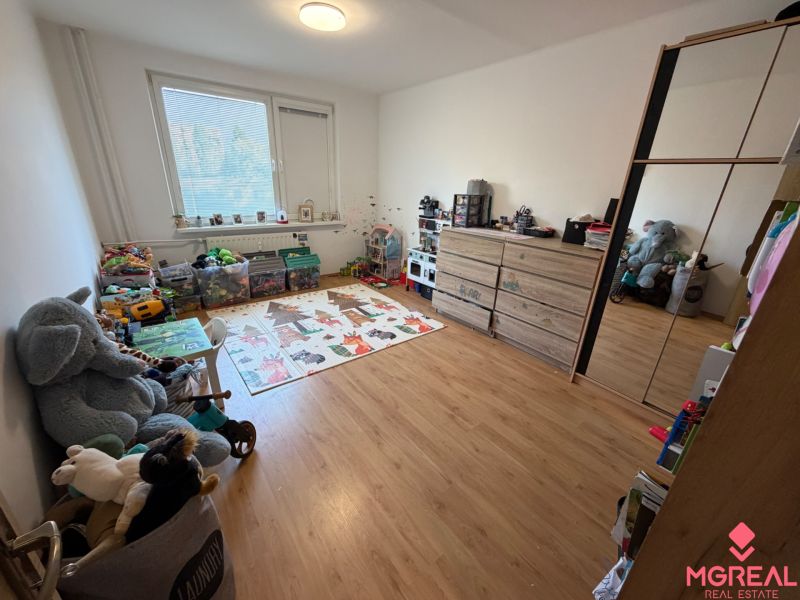 A children's room with toys and a wooden decor floor in a 3-room apartment.
