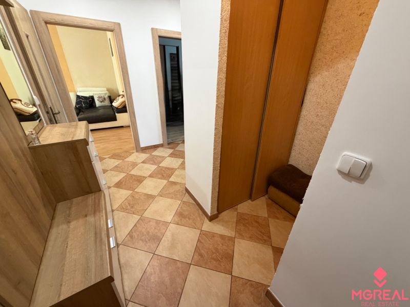 A hallway in a 3-room apartment with tiles and a built-in wardrobe.