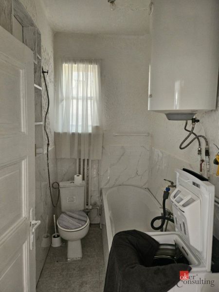 A narrow space with white doors and simple lighting in a family house.