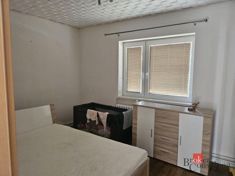 Bathroom with a bathtub, toilet, and washing machine in a family house. Decorative walls.