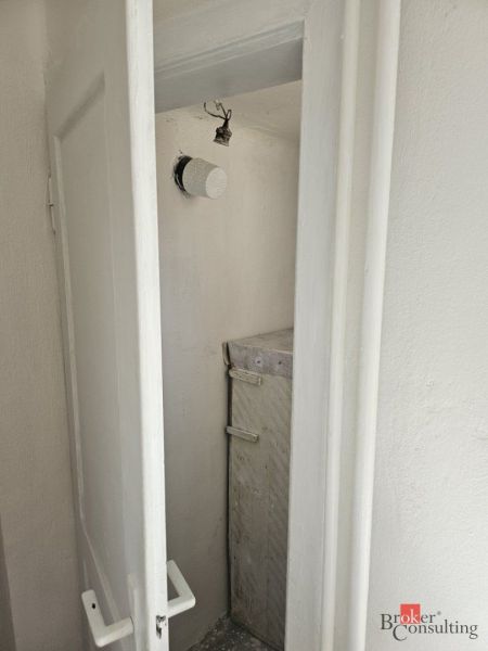 A narrow space with white doors and simple lighting in a family house.