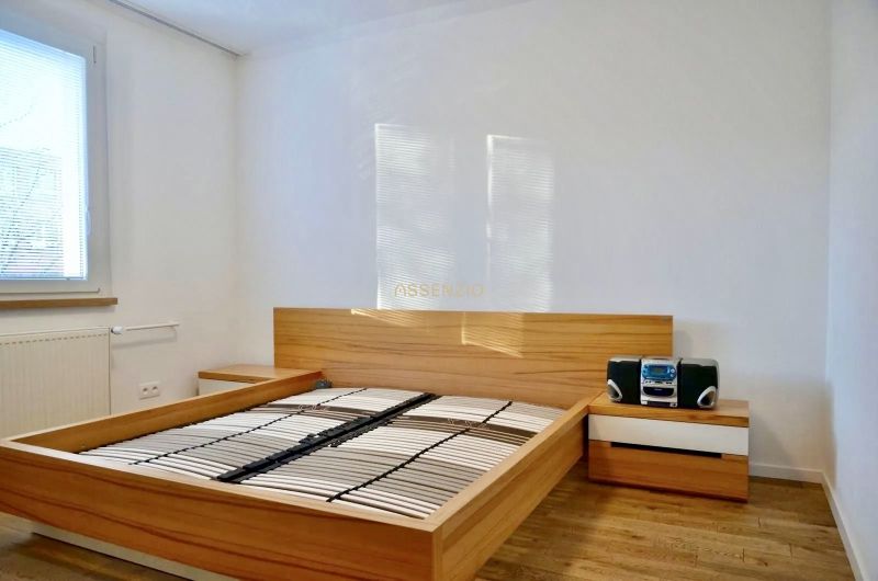 A bedroom with a bed and nightstands in a 3-room apartment, floor with wood decor.