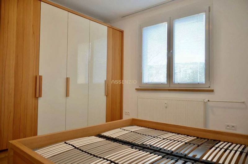 Bedroom with a bed without a mattress, built-in wardrobe and window, 3-room apartment.