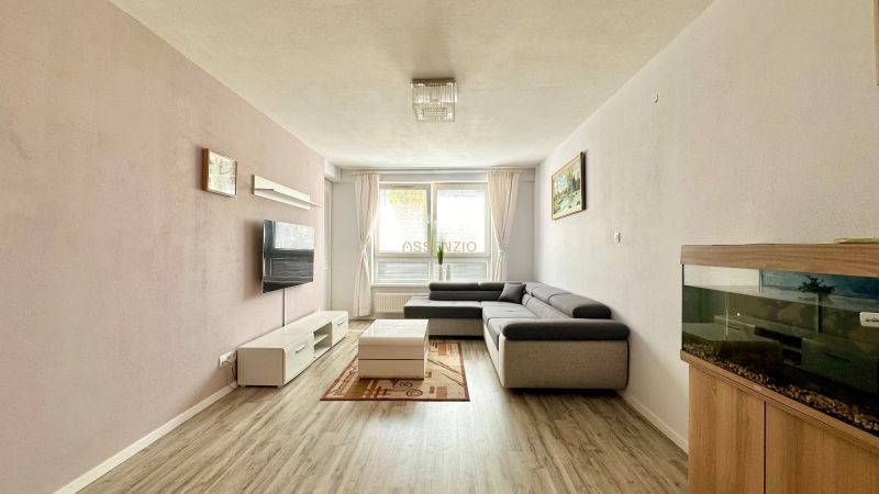 Living room in a 3-room apartment with a corner sofa and a wooden decor floor.