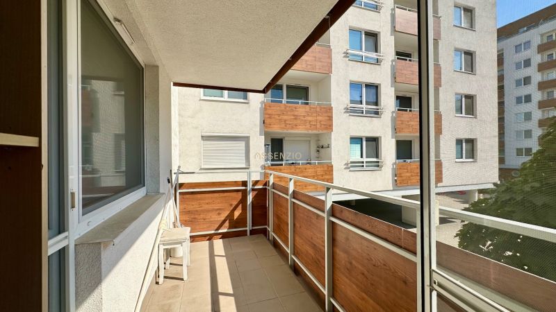 A balcony in a 3-room apartment with a view of the neighboring apartment building.