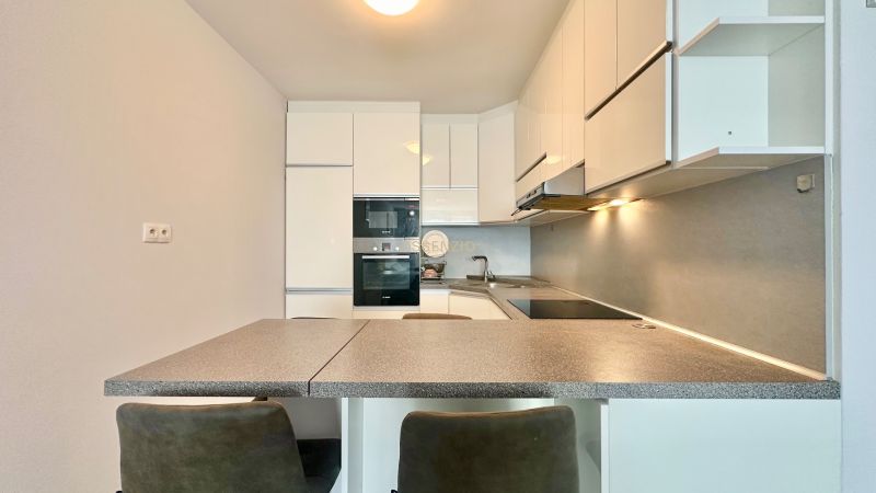 A kitchen in a 3-room apartment with a corner unit, a cooktop, and built-in appliances.