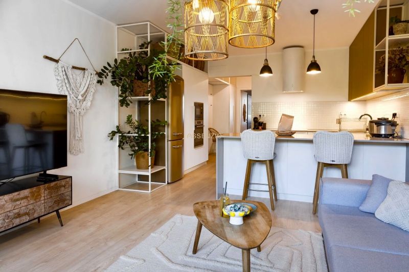2-room apartment with wood-patterned flooring, plants, and decorative lighting in the living room.