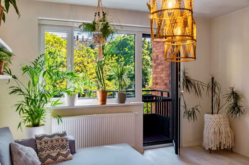 Seating with plants, a balcony, and knitted decorations in a 2-room apartment.