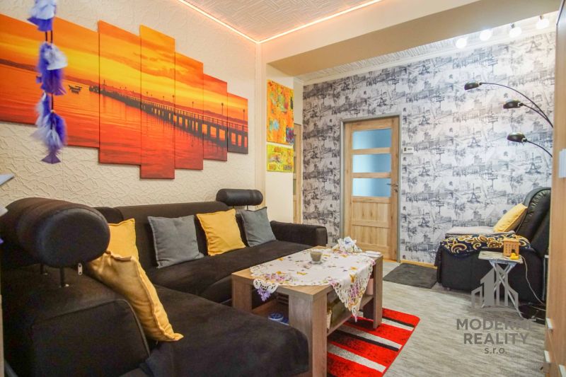 Living room in a two-room apartment with a comfortable sofa and colorful decorations.