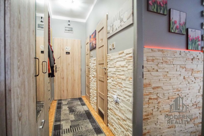 A hallway in a 2-room apartment with stone on the walls and decorative lighting.