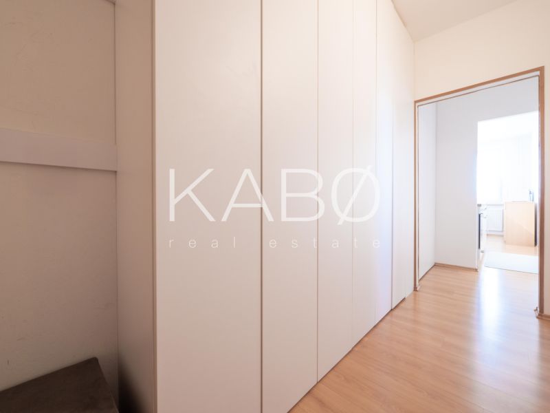 A hallway with a wardrobe and a wooden decor floor in a 2-room apartment.
