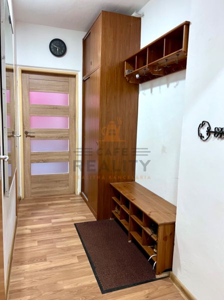 Entrance hallway with wood-patterned flooring, coat hooks, and a wardrobe in a 2-room apartment.