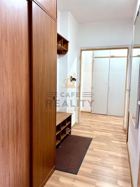A hallway with a wooden decor floor and built-in wardrobes in a 2-room apartment.
