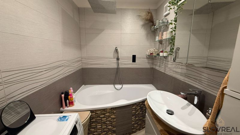 A bathroom with a bathtub and decorative tiles in a 4-room apartment.