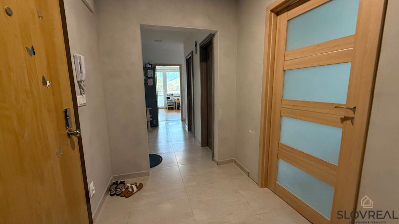 A hallway with light tiles and wooden doors in a 4-room apartment.
