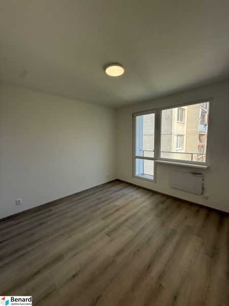 An empty room with a wooden floor and white walls in a 3-room apartment.